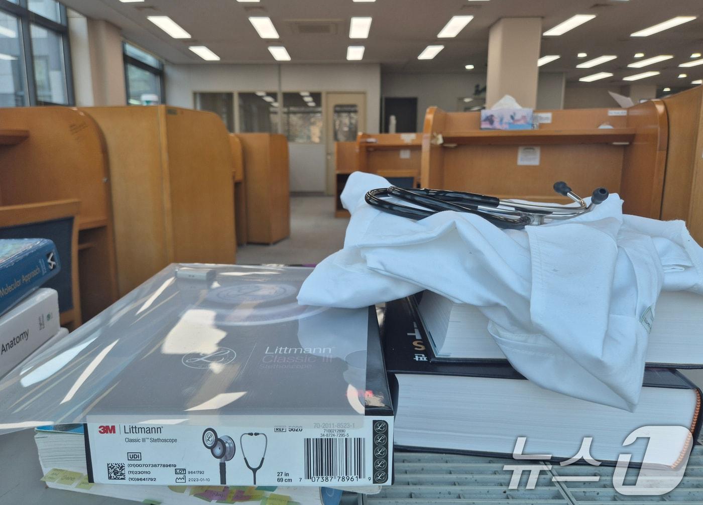 본문 이미지 - 경기도의 한 의과대학 도서관에 전공서적과 가운, 청진기가 놓여 있다. /뉴스1 ⓒ News1 김영운 기자