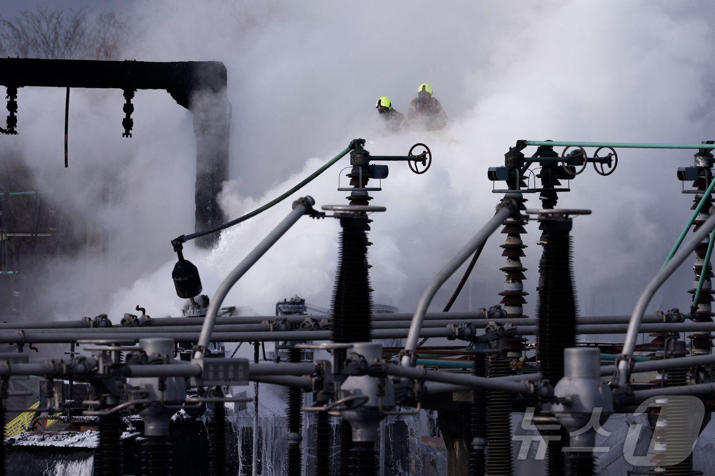 21일(현지시간) 영국 런던 히스로 공항 인근 변전소에서 화재가 발생해 연기가 솟아 오르는 현장서 소방대원이 진화를 하고 있다. 2025.03,22 ⓒ AFP=뉴스1 ⓒ News1 우동명 기자