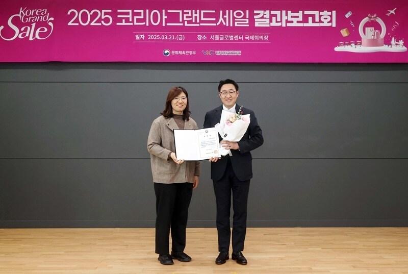 본문 이미지 -  신세계면세점은 지난 21일 서울 종로구 서울글로벌센터에서 열린 &#39;2025 코리아그랜드세일 결과보고 및 우수 참여기업 시상식&#39;에서 우수 참여기업으로 선정돼 문화체육관광부 장관 표창을 받았다. &#40;오른쪽&#41;곽종우 신세계디에프 마케팅 담당이 장미란 문화체육관광부 제2차관과 기념촬영을 하는 모습.&#40;신세계면세점 제공&#41;