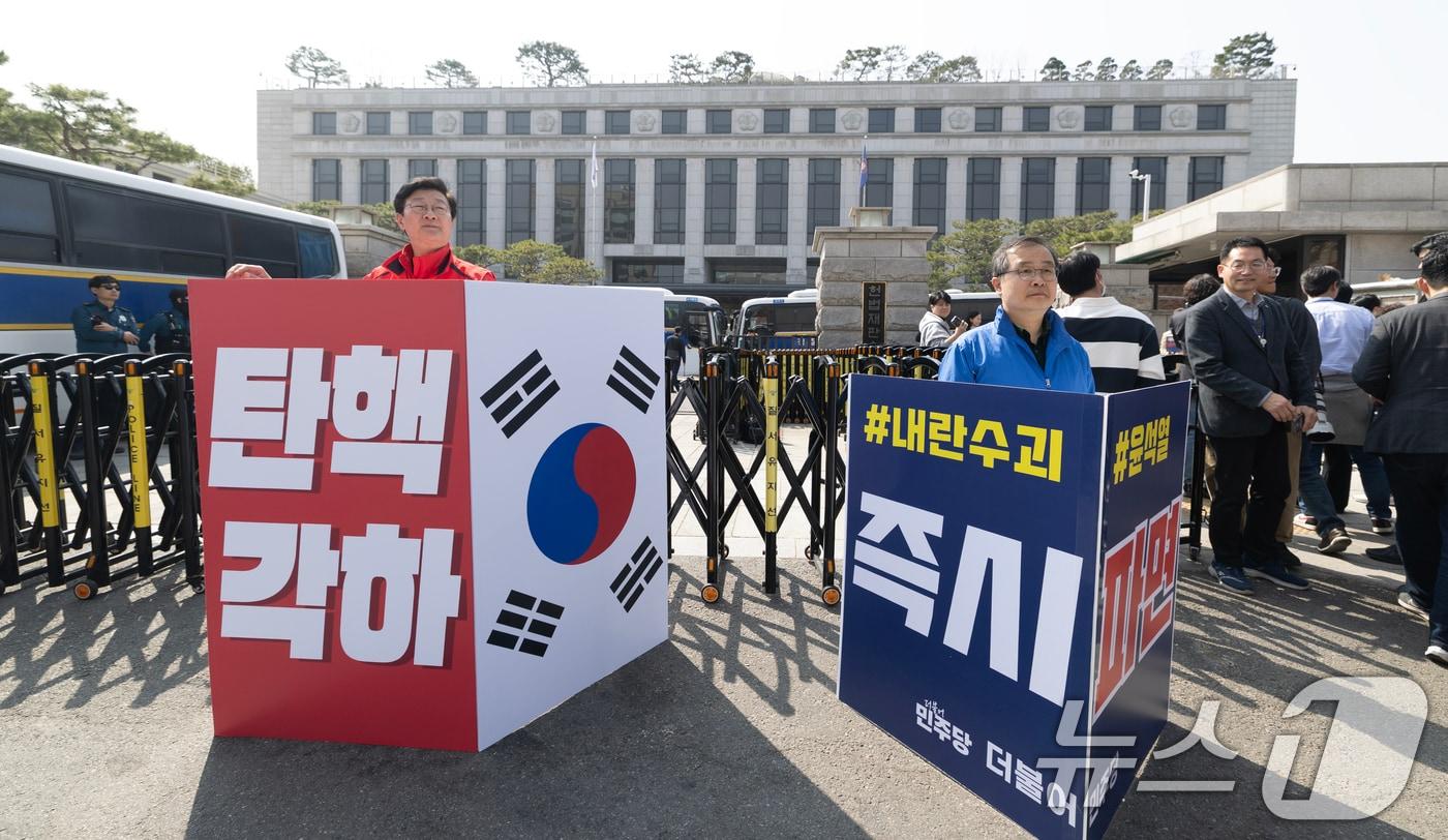 &#39;12·3 비상계엄&#39; 관련 한덕수 국무총리의 탄핵 심판 사건 선고를 하루 앞둔 23일 서울 종로구 헌법재판소 앞에서 국민의힘, 더불어민주당 관계자들이 각각 탄핵 찬·반 1인 시위를 하고 있다. 2025.3.23/뉴스1 ⓒ News1 이승배 기자