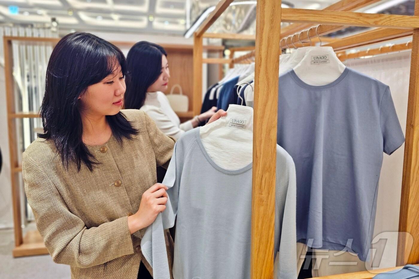 본문 이미지 - 신세계백화점 센텀시티 관계자가 여성 디자이너 브랜드 유라고의 제품을 소개하고 있다.(신세계 센텀시티 제공. 재판매 및 DB 금지)