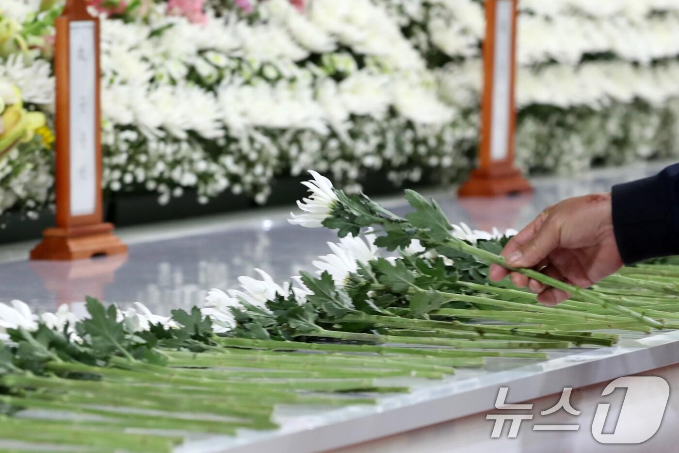 24일 경남 창녕군 창녕군민체육관에 마련된 '산청군 산불 진화대 사고 희생자 합동분향소'에서 조문객이 헌화하고 있다. 2025.3.24/뉴스1 ⓒ News1 윤일지 기자