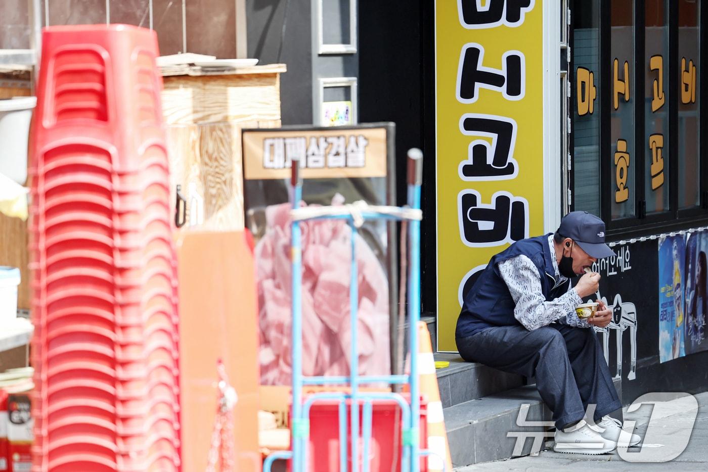 본문 이미지 - 서울 종로구 탑골공원 인근 골목에서 한 어르신이 간편 죽으로 끼니를 때우고 있다. ⓒ 뉴스1 민경석 기자