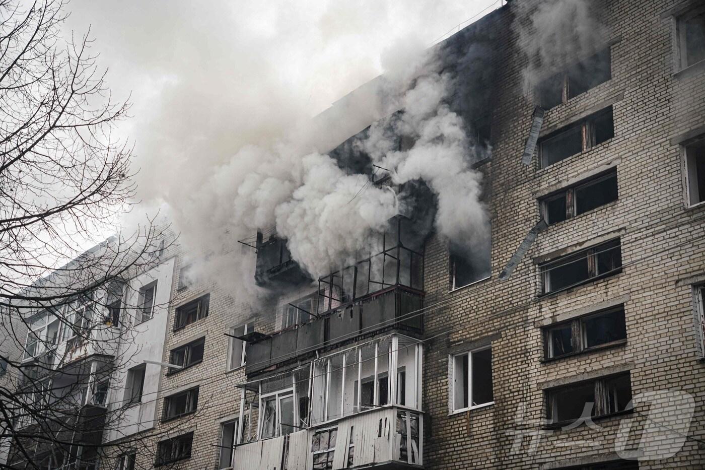 본문 이미지 - 24일(현지시간) 우크라이나 수미에서 러시아 군의 미사일 포격을 받아 연기가 솟아 오르는 아파트가 보인다. 2025.03.25 ⓒ AFP=뉴스1 ⓒ News1 우동명 기자