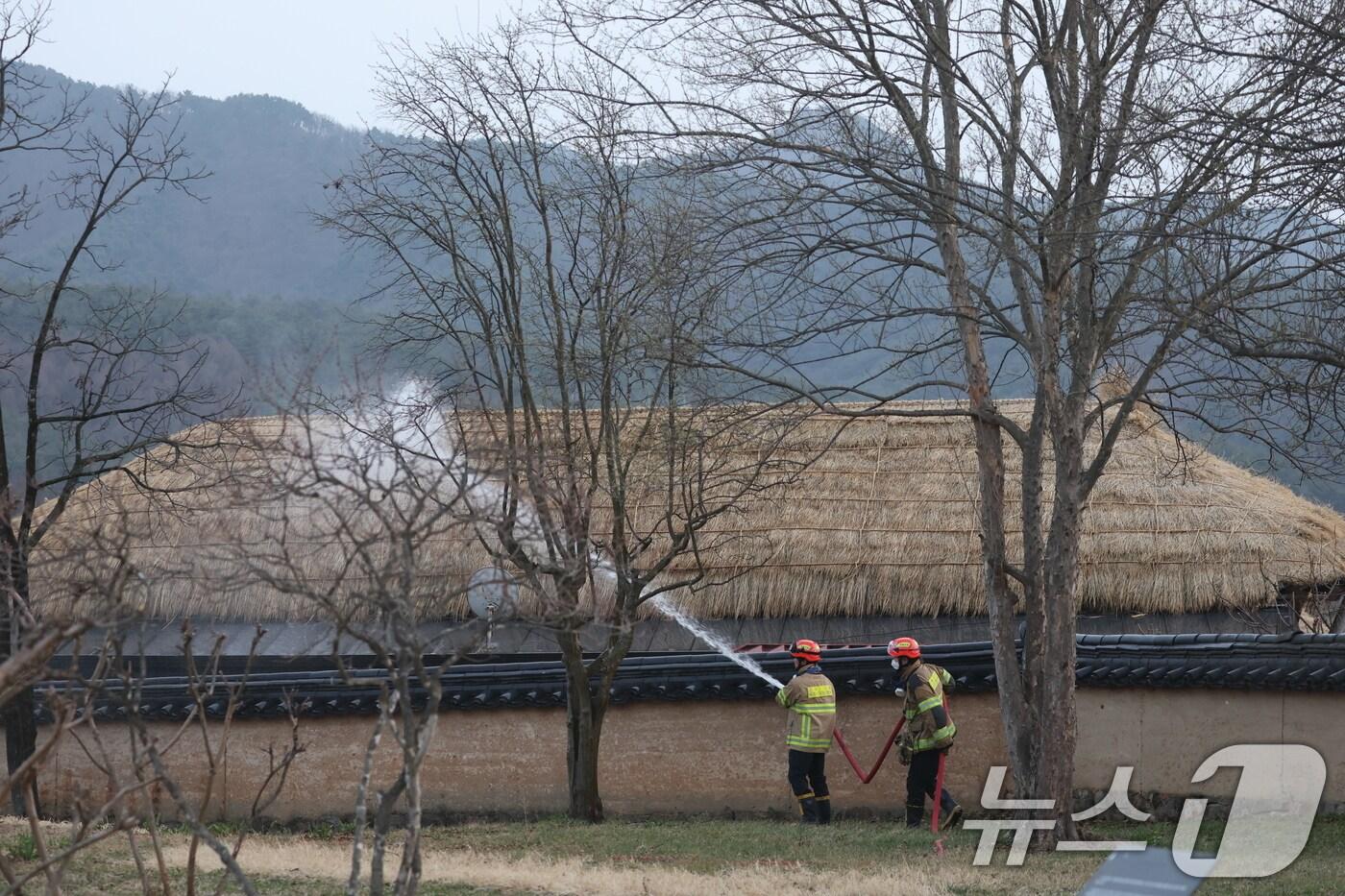 경북 의성군 산불이 나흘째 이어지고 있는 25일 오후 경북 안동시 하회마을에서 관계자들이 화재에 대비해 초가지붕에 물을 뿌리고 있다.2025.3.25/뉴스1 ⓒ News1 김영운 기자