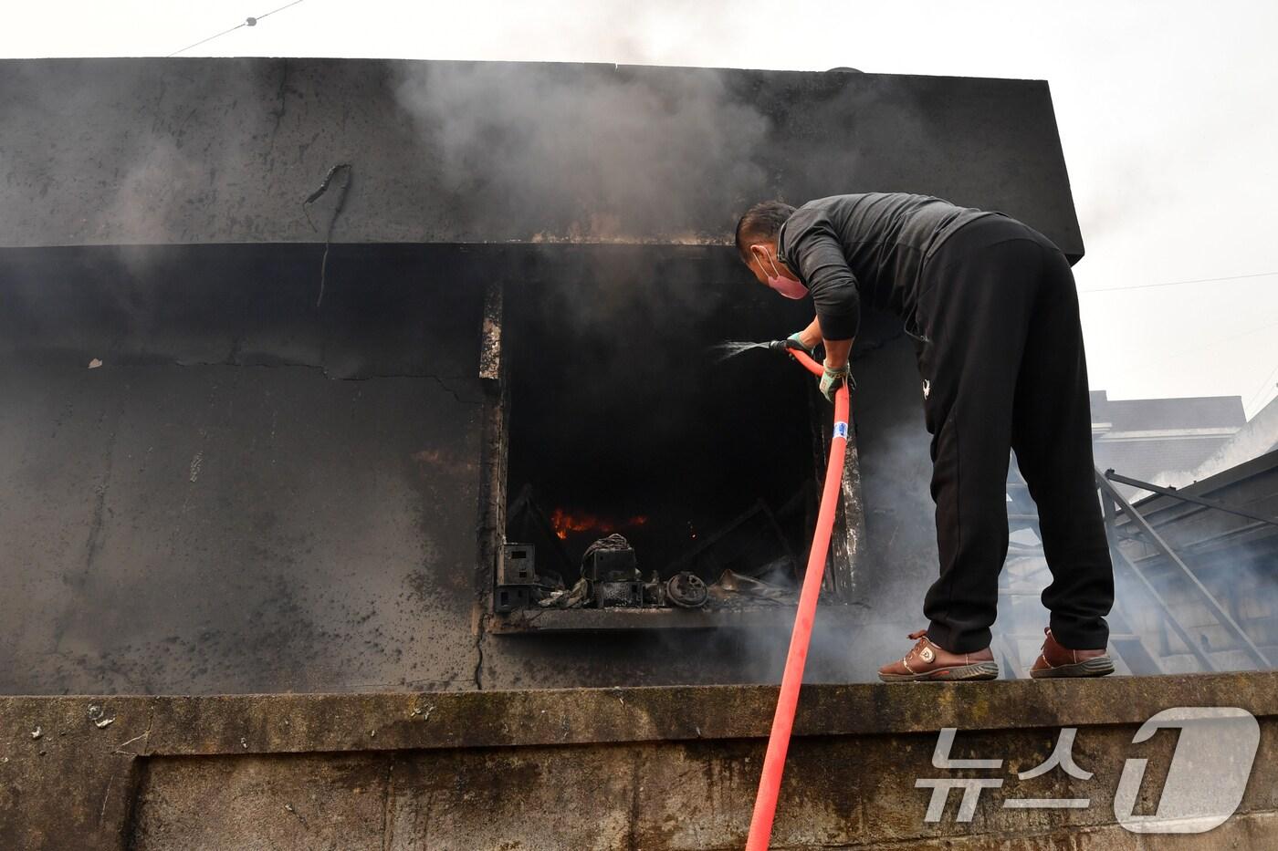 경북 의성산불이 강풍을 타고 영덕으로 확산된 26일 오전 매정1리 마을에서 주민이 주택에 님아 있는 불을 끄고 있다. 2025.3.26/뉴스1 ⓒ News1 최창호 기자