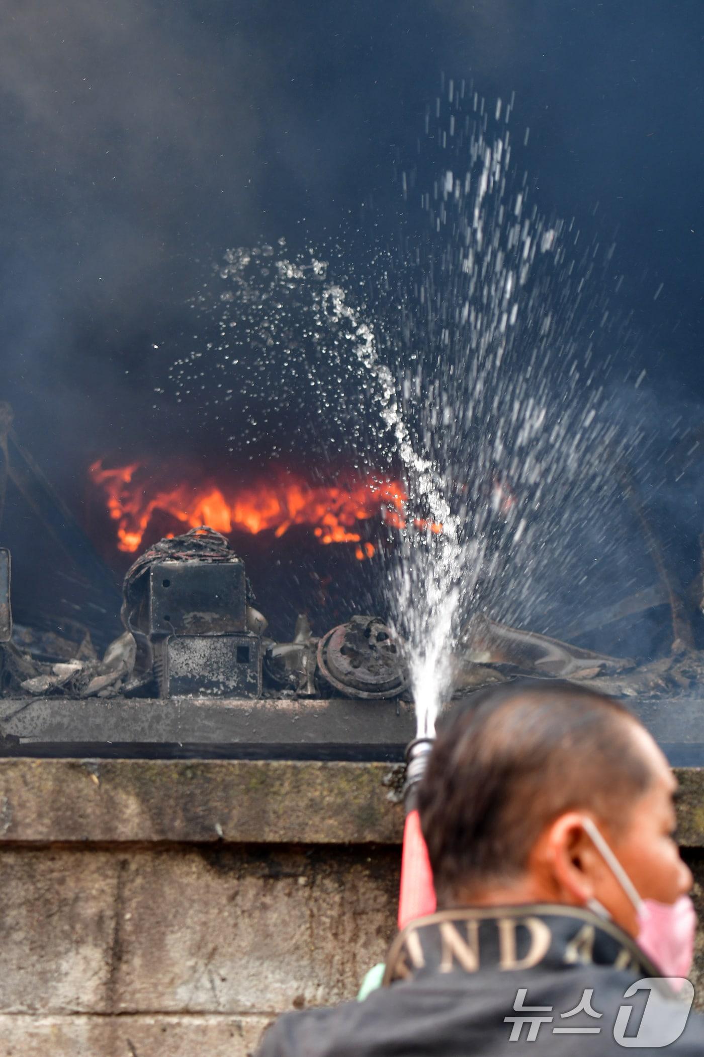 본문 이미지 - 경북 의성산불이 강풍을 타고 영덕으로 확산된 26일 오전 매정1리 마을에서 주민이 주택에 님아 있는 불을 끄고 있다. 2025.3.26/뉴스1 ⓒ News1 최창호 기자
