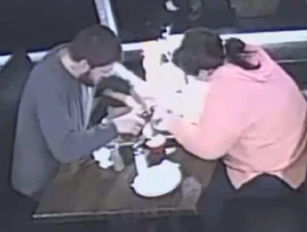 본문 이미지 - 미국 테네시주 식당에서 식사중인 한 커플. 여성이 머리카락을 뽑고 남성이 팔을 뻗어 받은 후 음식에 넣는 영상 캡처(사진 출처 wdbj7.com)