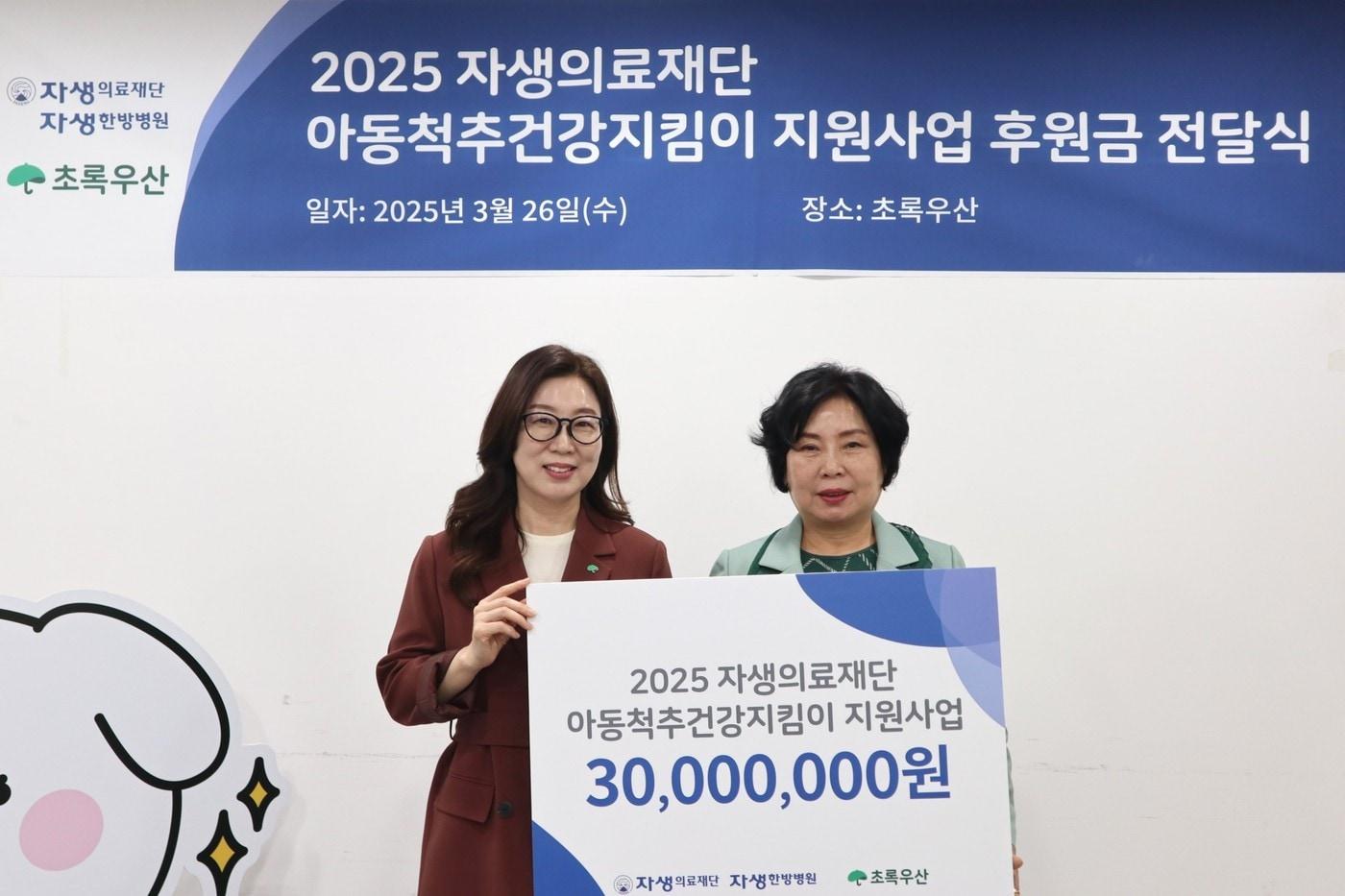 자생의료재단 관계자(오른쪽)가 아동척추건강지킴이 후원금을 전달하고 있다.(자생한방병원 제공)