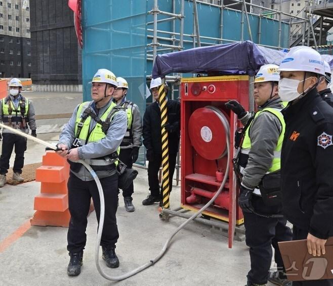 본문 이미지 - 공사장 관계자가 간이소화장치 정상 작동 여부를 점검하고 있다.(소방청 제공)