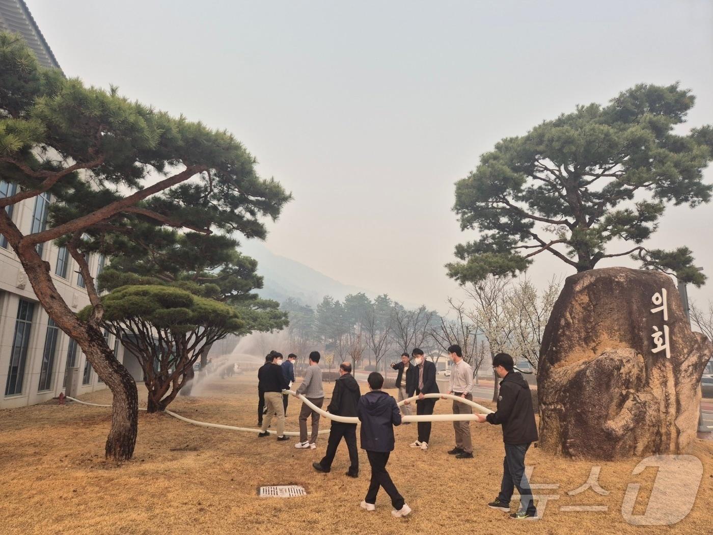 본문 이미지 - 지난 23일 경북 의성 산불 화재로 경북도청사도 안전 하지 않아 비상 소방대응체제로 건물 주변에 물을 뿌리고 있다. 2025.3.27/뉴스1 ⓒ News1 김대벽기자