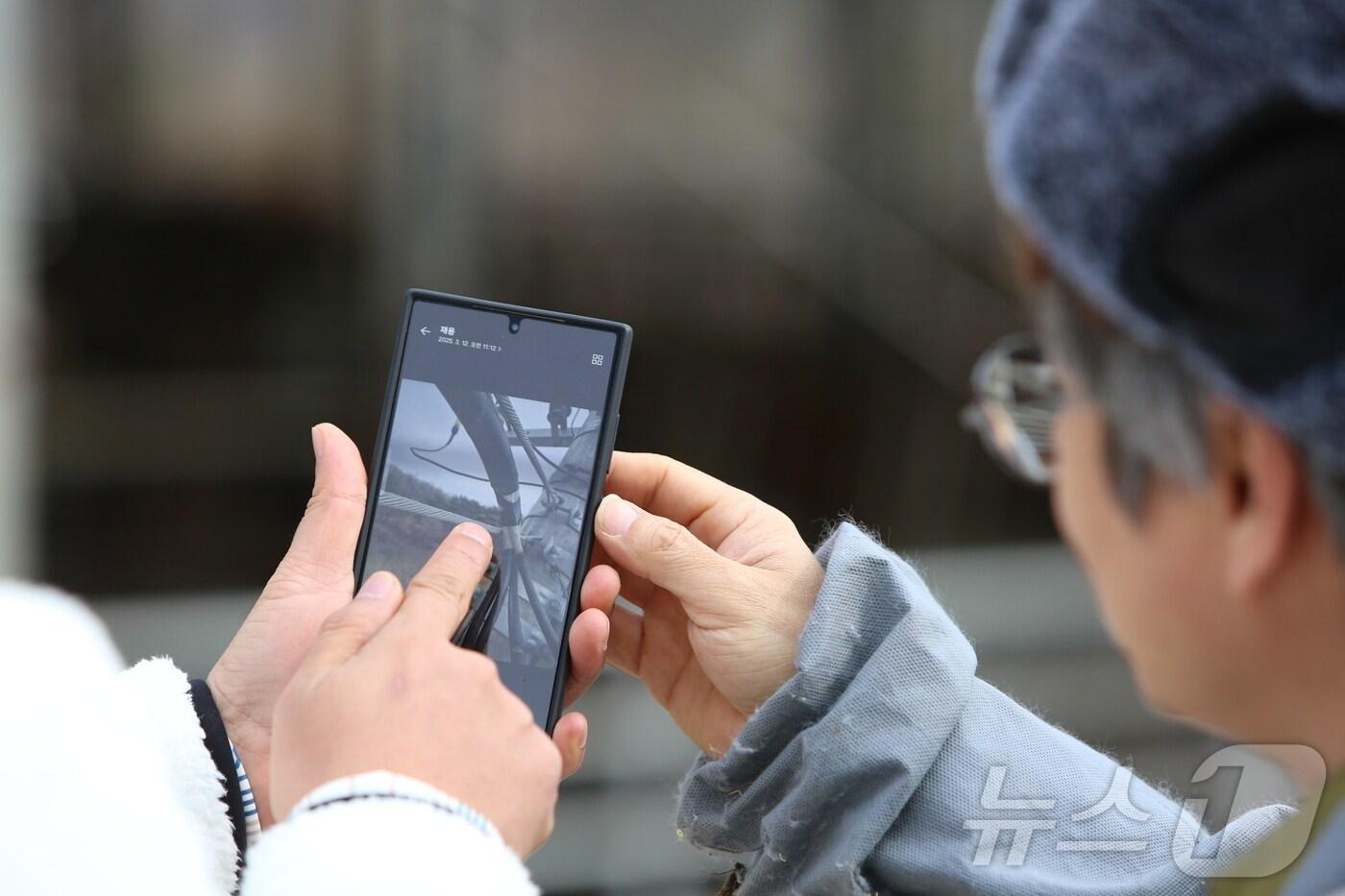 제천시 봉양읍 한우농가 농장주가 카메라에 찍힌 농장 주변 전봇대 전깃줄을 살펴보고 있다./뉴스1
