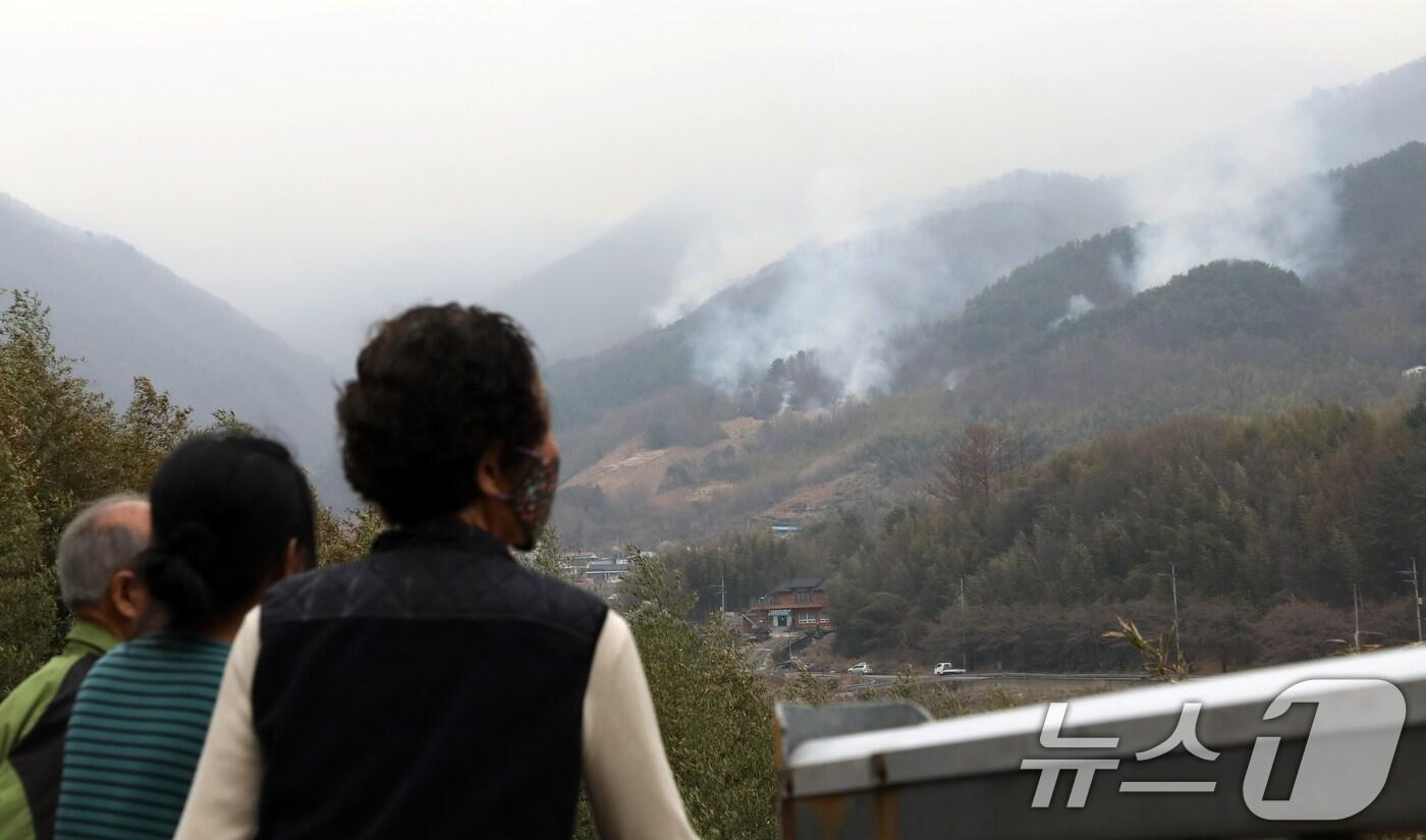 경남 산청·하동 산불 일주일째인 27일 오후 주민들이 지리산과 인접한 산청군 시천면 동당마을 위로 피어오르는 산불 연기를 지켜보고 있다. 2025.3.27/뉴스1 ⓒ News1 윤일지 기자