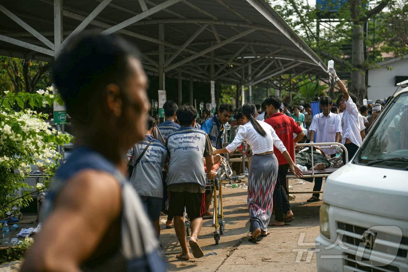 본문 이미지 - 28일(현지시간) 미얀마 중부에서 7.7 강진이 발생한 가운데 수도 네피도의 한 병원 부지에서 의료진이 부상자들을 옮기고 있다. 2025.03.28 ⓒ AFP=뉴스1 ⓒ News1 최종일 선임기자