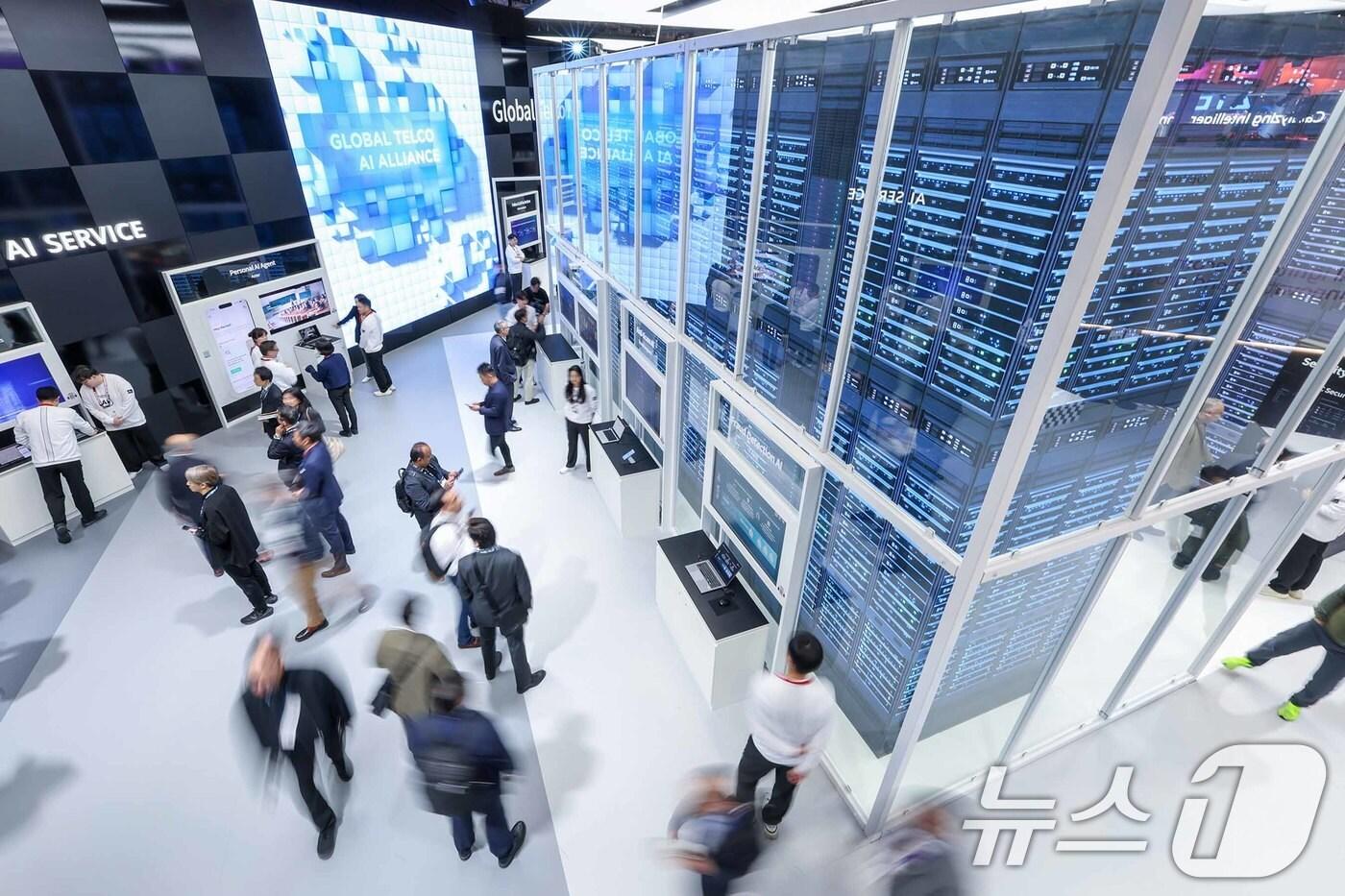 3일(현지시간) 스페인 바르셀로나 피라 그란 비아 전시장에서 열린 '모바일 월드 콩그레스(MWC) 2025'를 찾은 관람객들이 SK텔레콤 부스에서 'AI 데이터 센터'를 살펴보고 있다. MWC는 전세계 800여 개의 이동통신사가 참여하는 세계이동통신사업자연합회(GSMA)가 주관하는 행사로, 미국과 독일에서 각각 열리는 CES, IFA와 함께 3대 전자·IT 전시회로 꼽힌다. 올해 MWC에 참가하는 한국 기업은 187곳으로 지난해보다 22곳이 늘었다. 2025.3.3/뉴스1 ⓒ News1 민경석 기자
