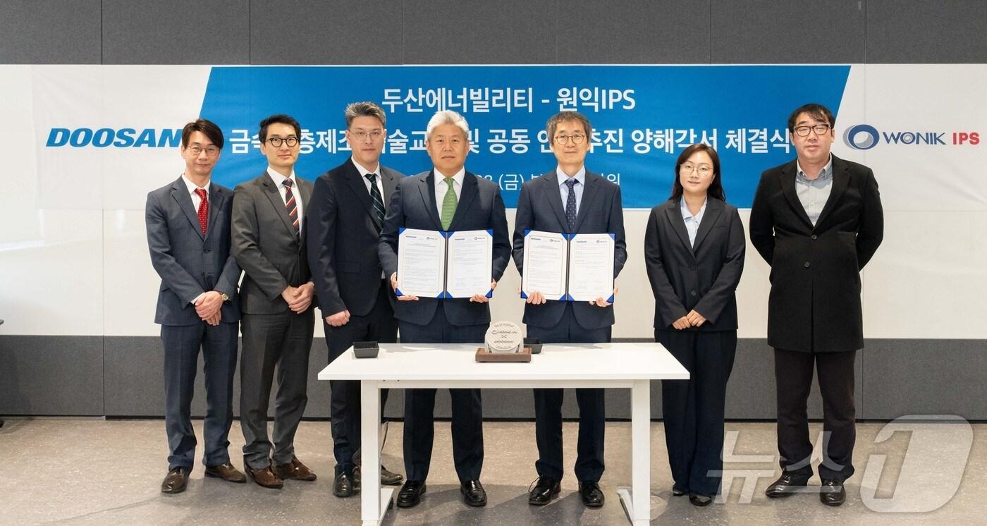 이희범 전략혁신 두산에너빌리티 담당(왼쪽에서 네 번째)과 이명범 원익IPS 선행개발본부 총괄(오른쪽에서 세 번째)이 28일 경기도 성남시 분당두산타워에서 열린 ‘적층제조 기술 교류 및 연구 추진’ 양해각서(MOU) 체결식에서 기념 촬영을 하고 있다.(두산에너빌리티 제공)