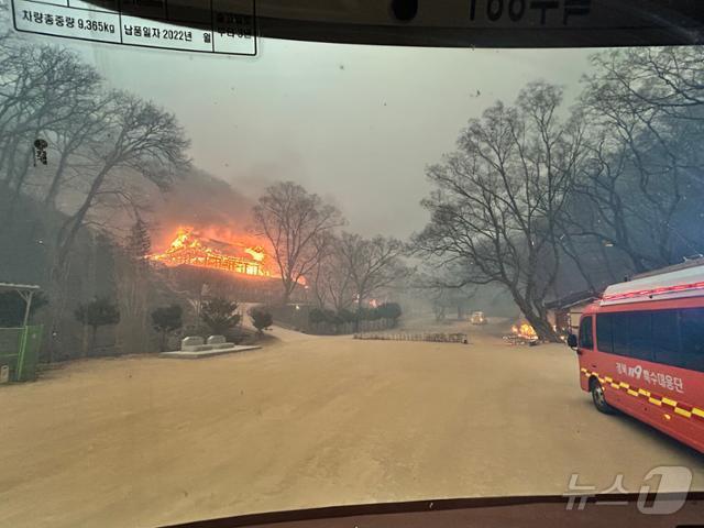 본문 이미지 - 지난 24일 경북119특수대응단 3팀 대원들이 경북 의성 고운사 입구 주차장에 도착해 바라본 고운사 모습. 경내 전각이 전소되고 있다. (경북119특수대응단 제공. 재판매 및 DB 금지)/뉴스1