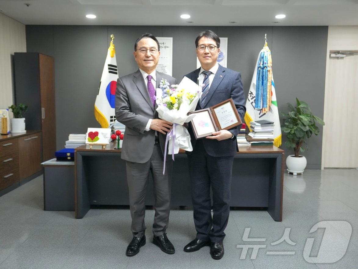본문 이미지 - 삼환기업 유창훈 대표이사&#40;오른쪽&#41;가 시정발전 유공시민 표창패와 꽃다발을 들고 박상돈 천안시장과 기념촬영을 하고 있다. &#40;SM그룹 제공&#41;