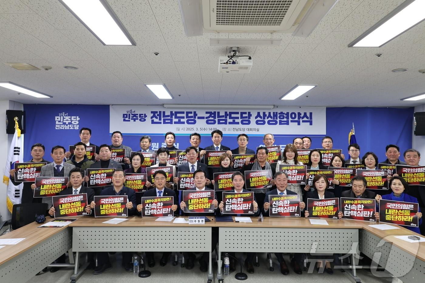 민주당 전남도당과 경남도당 관계자들이 상생협약을 체결한 뒤 퍼포먼스를 진행하고 있다.(민주당전남도당 제공)/뉴스1     