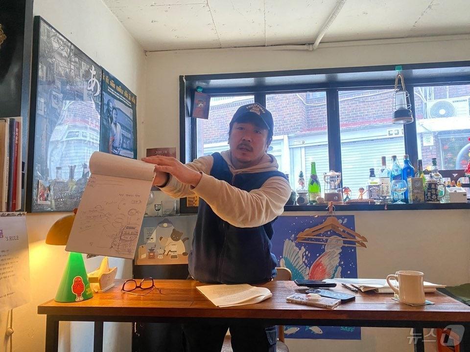 본문 이미지 - 배우 겸 감독 양익준이 5일 서울 성북구의 한 주점에서 취재진과 만나 폭행 혐의를 받게 된 데 대한 입장을 전하며 문제가 됐던 종이 뭉치를 공개하고 있다. / 뉴스1 장아름 기자