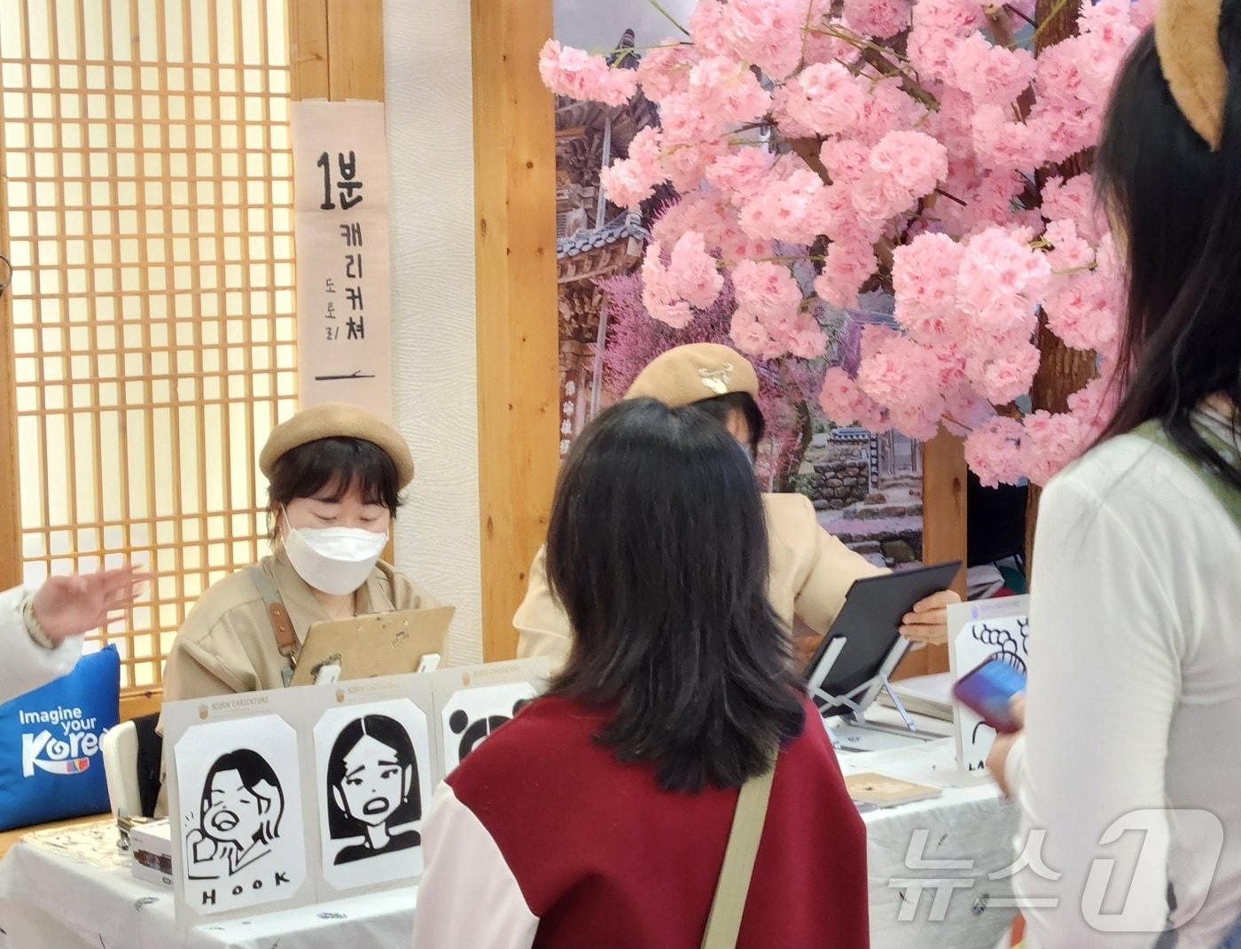 본문 이미지 - 광저우 K-관광 로드쇼와 연계해 운영하는 봄꽃 여행테마 홍보관에서 관람객들이 체험 프로그램에 참여하고 있다.(한국관광공사 제공)