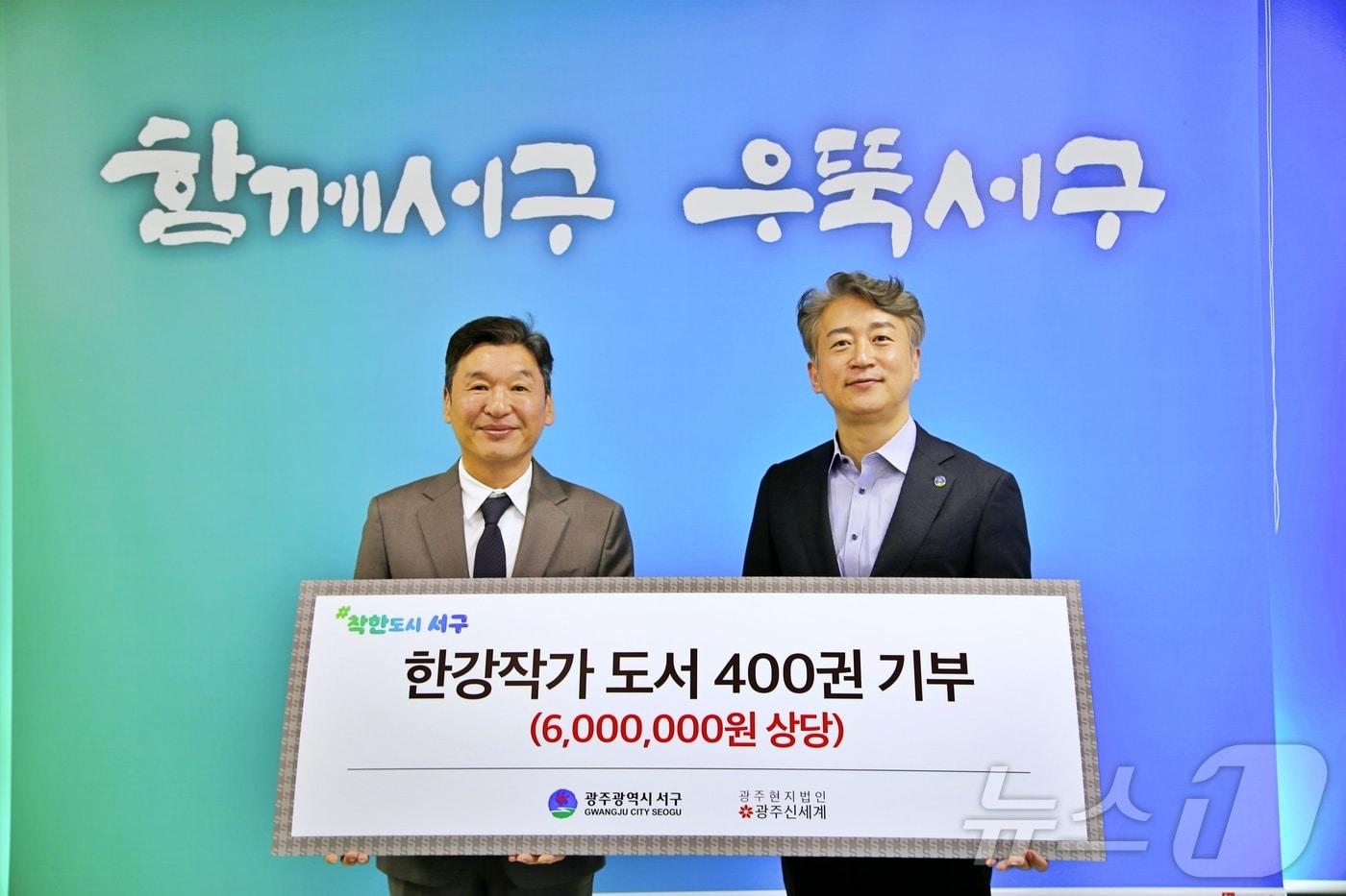 6일 광주 서구청에서 한강 작가 도서 전달식이 열려 이동훈 광주신세계 대표이사가(왼쪽) 김이강 광주 서구청장에 전달하고 있다.(광주신세계 제공. 재배포 및 DB 금지)