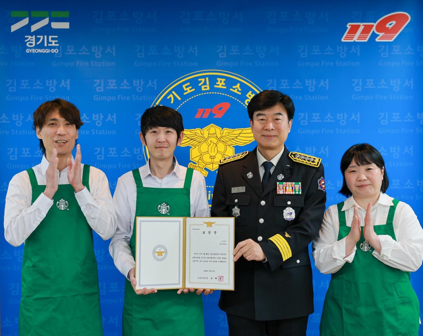 본문 이미지 -  6일 김포소방서에서 (왼쪽부터) 정태우 스타벅스 풍무역DT점 부점장, 박지훈 수퍼바이저, 하효진 수퍼바이저가 (왼쪽 세번째)유해공 김포소방서 서장으로부터 현장 응급상황 대처 공로를 인정받는 표창을 받은 후 기념 촬영을 하는 모습.(스타벅스 코리아 제공) 