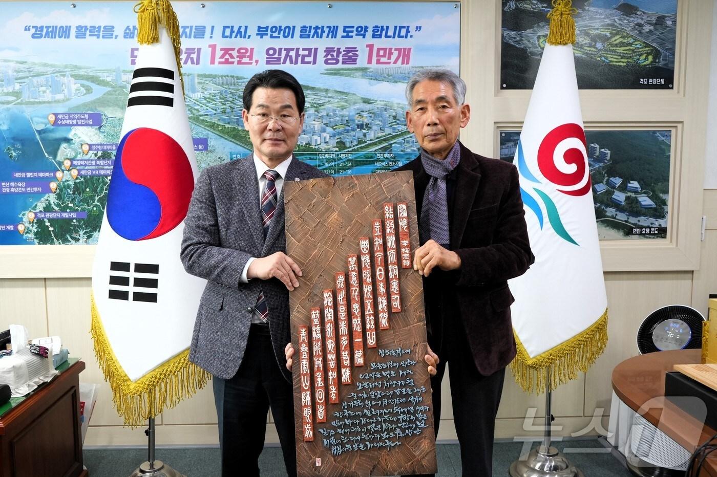 본문 이미지 - 지천 우암 김법준 작가(오른쪽)가 7일 부안군에 매창시 서각 작품 44점을 기증하고 있다.(부안군 제공. 재판매 및 DB금지)