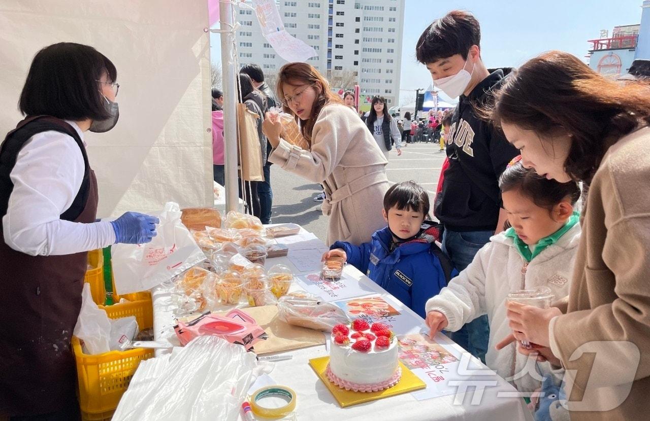 본문 이미지 - 8일 전북자치도 완주군 삼례농협 공영주차장에서 열린 '삼례딸기축제'를 찾은 가족이 딸기 케이크를 바라보고 있다. 제23회 '삼례딸기축제'는 9일까지 열린다.(완주군 제공. 재판매 및 DB금지)2025.3.8/뉴스1 ⓒ News1 강교현 기자
