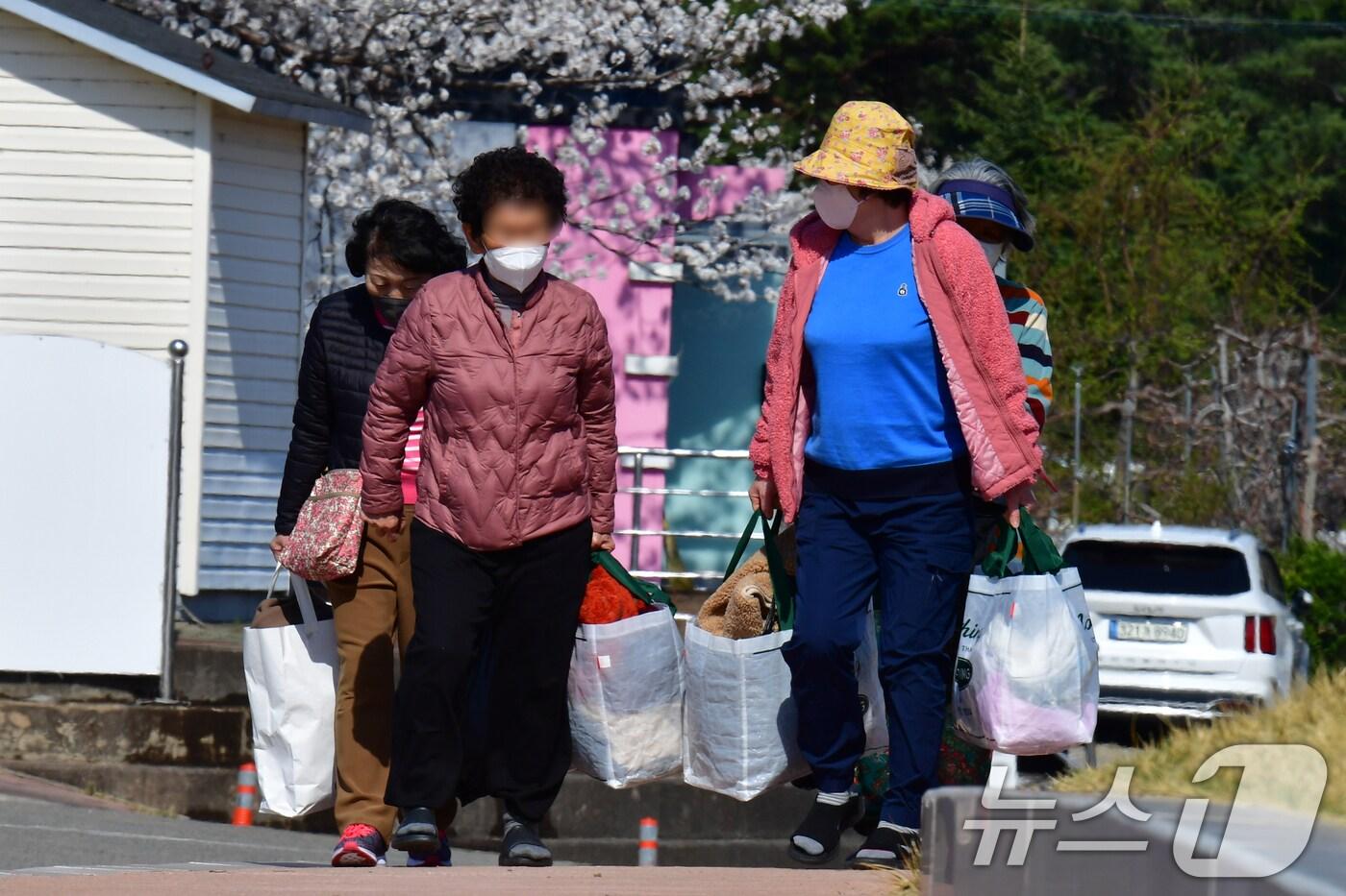 산불 피해지역인 경북 영덕군 이재민들이 구호물품으로 도착한 옷 가지를 챙겨들고 대피소인 국민체육센터로 발길을 옮기고 있다. 헌옷은 27일부터 매일 1톤 화물차 2대 분량이 도착하고 있다. 2025.4.1/뉴스1 ⓒ News1 최창호 기자