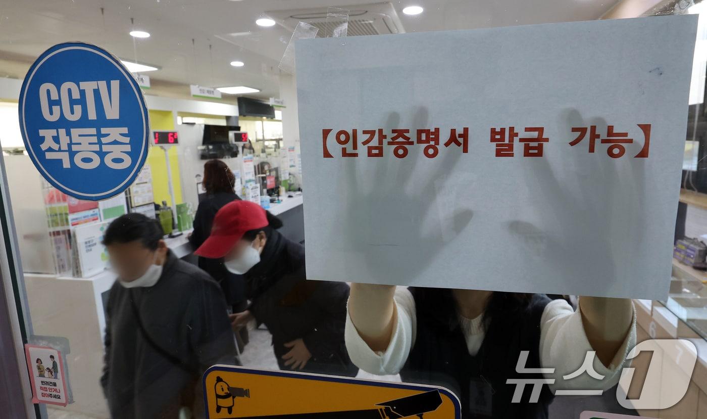 본문 이미지 - 1일 서울 시내의 한 동사무소에서 관계자가 인감증명서 발급 가능 안내문을 붙이고 있다.. 2025.4.1 ⓒ 뉴스1 이동해 기자