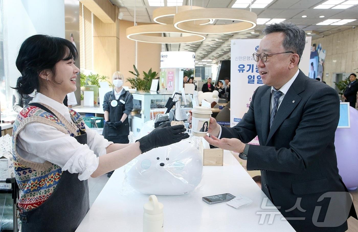 본문 이미지 - 지난 3월 31일 서울시 중구 신한은행 본점 1층 카페스윗에서 열린 유기동물 돕기 자선 행사에서 배우 장나라가 정상혁 신한은행장에게 커피를 전달하고 있다.(신한은행 제공)