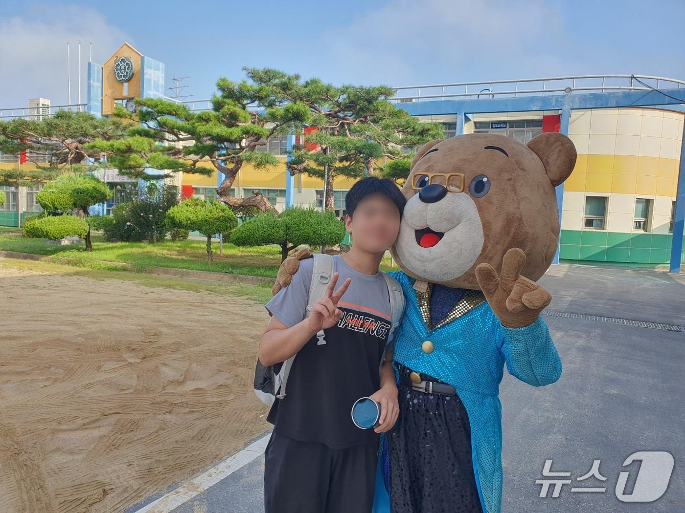 본문 이미지 - 김주현 논산 광석초 교장이 곰돌이 탈을 쓰고 등교하는 아이들을 맞이하고 있다. (광석초 제공. 재판매 및 DB금지)/뉴스1