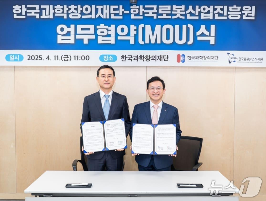 본문 이미지 - 강철호 한국로봇산업진흥원장(왼쪽)과 정우성 한국과학창의재단 이사장이 디지털·로봇 창의교육 활성화를 통한 미래 인재 양성을 위해 업무협약을 체결한 뒤 협약서를 펼쳐 보이고 있다.(로봇산업진흥원 제공. 재판매 및 DB 금지)