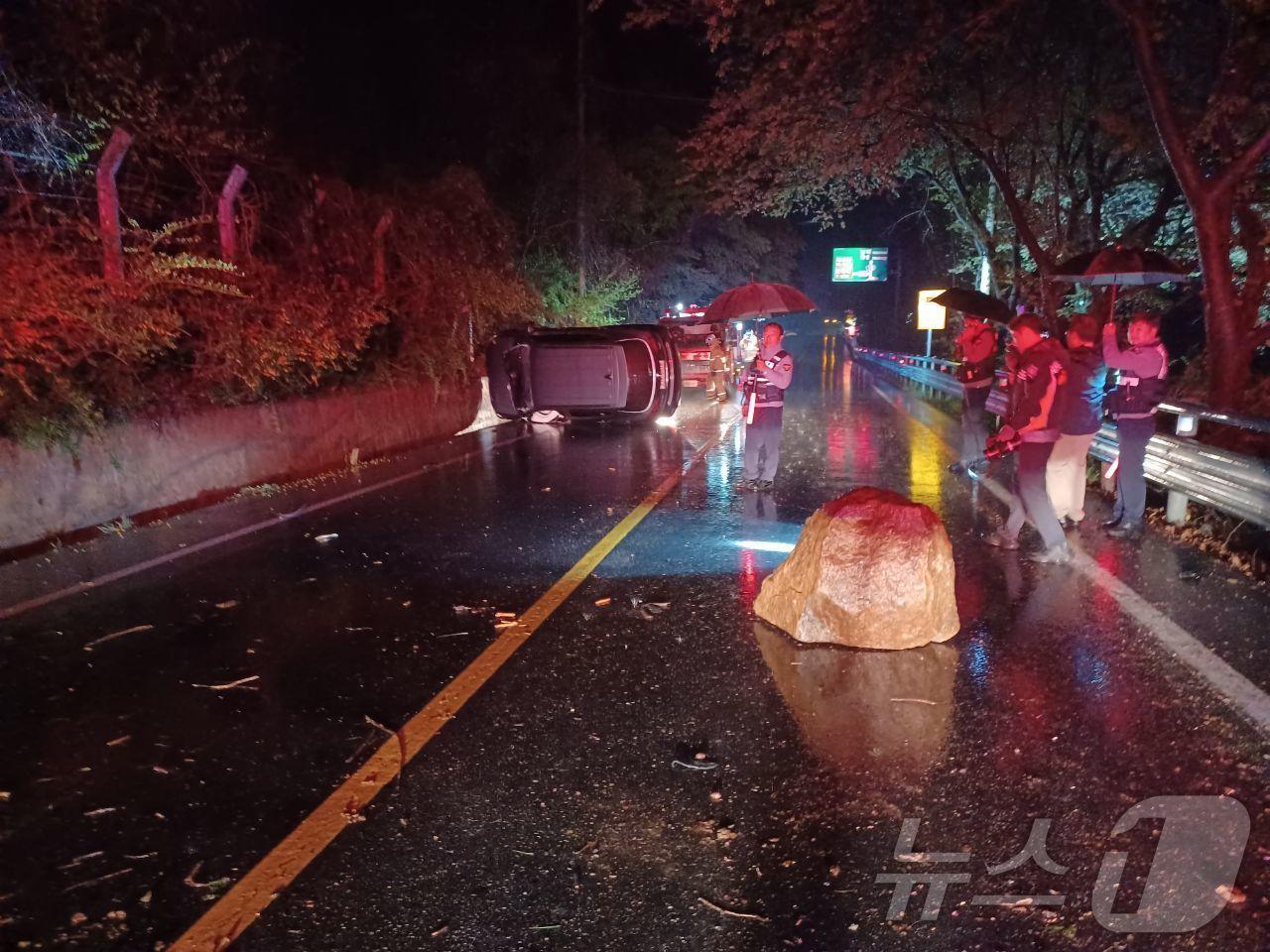 본문 이미지 - 12일 오후 9시 46분쯤 전남 구례군 토지면의 한 도로변에서 바위가 떨어지면서 차가 전도돼 소방당국이 차량에 고립된 운전자 1명을 구조하고 있다. (구례소방 제공. 재판매 및 DB금지) 