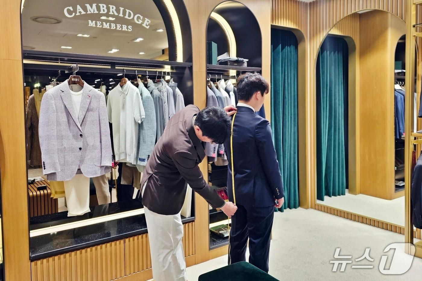 신세계백화점 센텀시티에 입점한 브랜드 캠브리지 멤버스에서 직원이 손님의 맞춤형 정장 제작을 위해 몸길이를 측정하고 있다.(신세계 센텀시티 제공. 재판매 및 DB 금지)