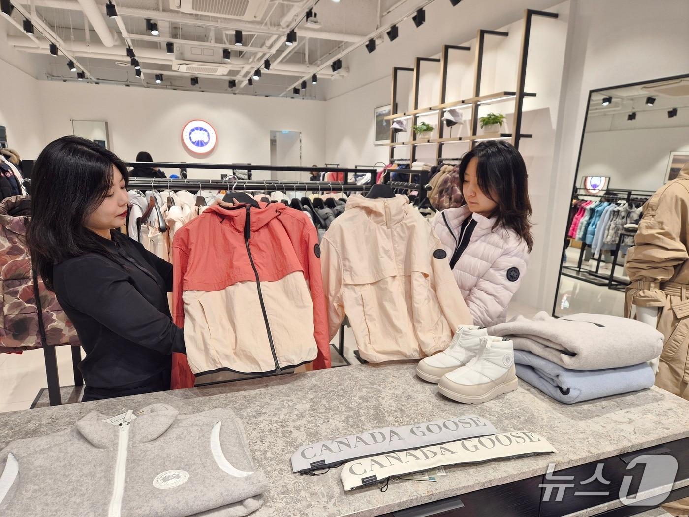 본문 이미지 - 데몰 동부산점 1층 '캐나다구스'에서 직원이 아우터를 소개하고 있다.)롯데몰 동부산점 제공. 재판매 및 DB 금지)