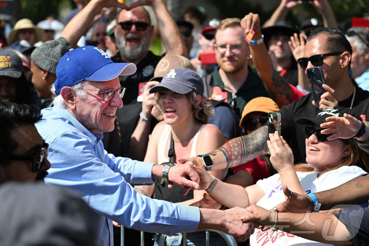 버니 샌더스 미 상원의원(버몬트)이 12알(현지시간) 로스앤젤레스(LA) 글로리아 몰리나 그랜드파크에서 열린 집회에서 연설 후 지지자들고 악수하고 있다. 2025.04.12.ⓒ AFP=뉴스1