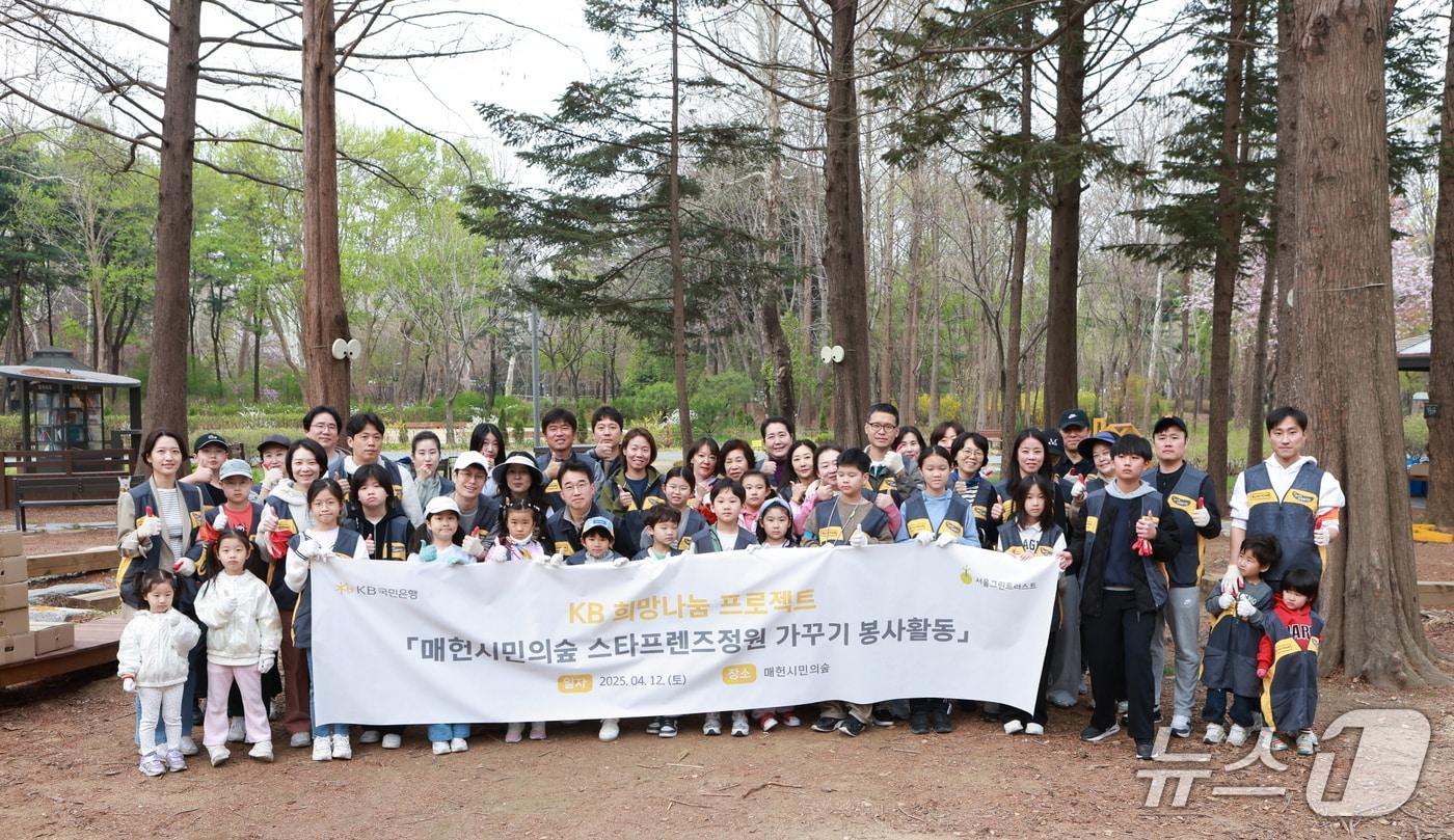 본문 이미지 -  지난 12일 서울 서초구 매헌시민의숲 내 'KB국민은행 스타프렌즈정원'에서 KB국민은행 임직원 및 가족이 봉사활동 후 기념촬영을 하고 있다.