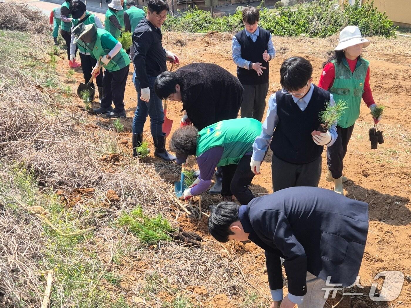 본문 이미지 - 충북 진천군 새마을회(회장 김일권)는 14일 2050 탄소중립 실천을 위해 진천중학교에 잣나무 2000그루를 심었다.(진천군 제공)/뉴스1