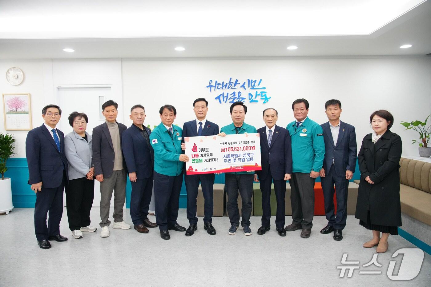 본문 이미지 - 이승로 성북구청장(좌측부터 여섯 번 째)과 주민대표단이 성금을 전달하고 있다.(성북구청 제공)