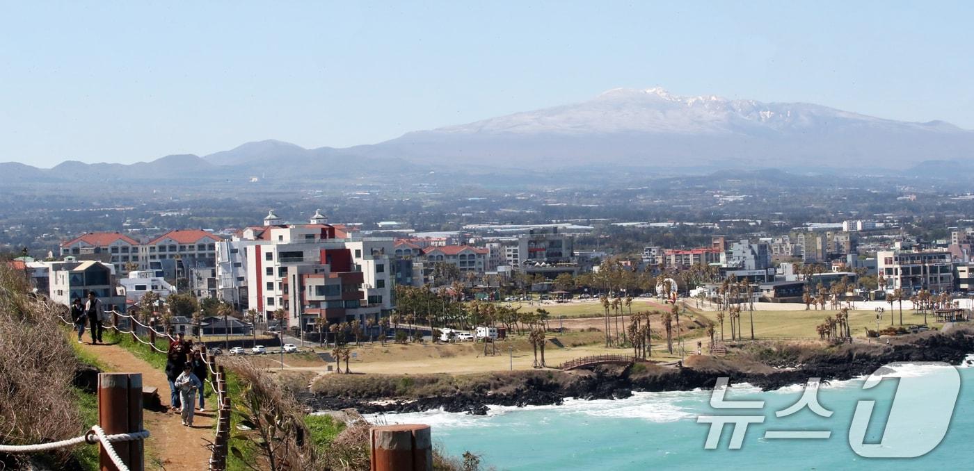 제주시 조천읍 서우봉에서 바라본 함덕해수욕장 뒤로 전날 내린 눈이 쌓여있는 한라산이 보이고 있다. /뉴스1