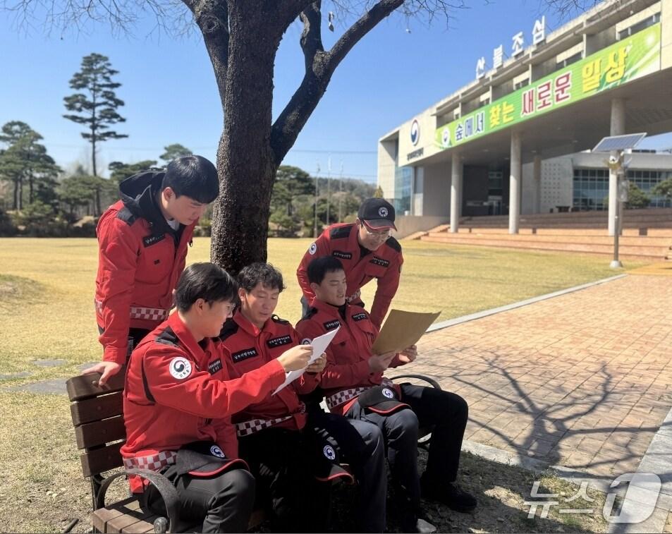 본문 이미지 - 산불진화대원들이 초등생들이 보낸 손 편지를 읽고 있다(산림청 제공.재판매 및 DB금지)/뉴스1