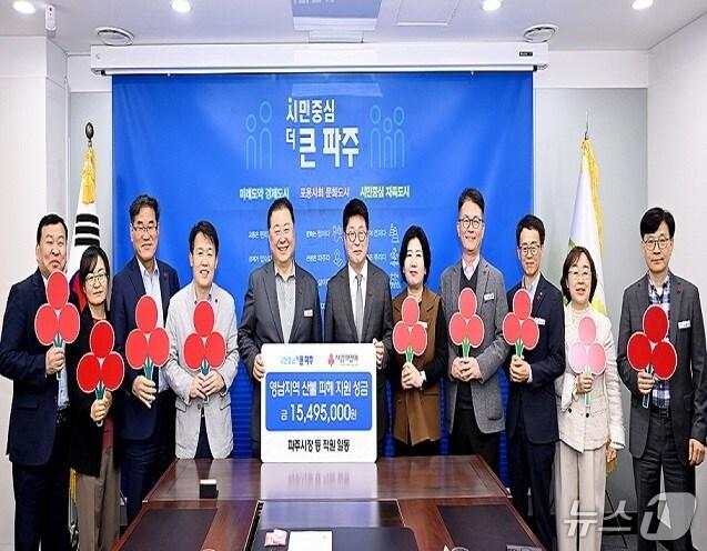 본문 이미지 - 지난 17일 김경일 파주시장&#40;왼쪽 5번째&#41;과 직원들이 권인욱 경기사회복지공동모금회 회장을 시청 접견실로 초청해 500여 명의 시청 직원들이 자발적으로 모금하여 마련한 성금을 전달한 뒤 기념촬영을 하고 있다. &#40;파주시 제공, 재판매 및 DB금지&#41;