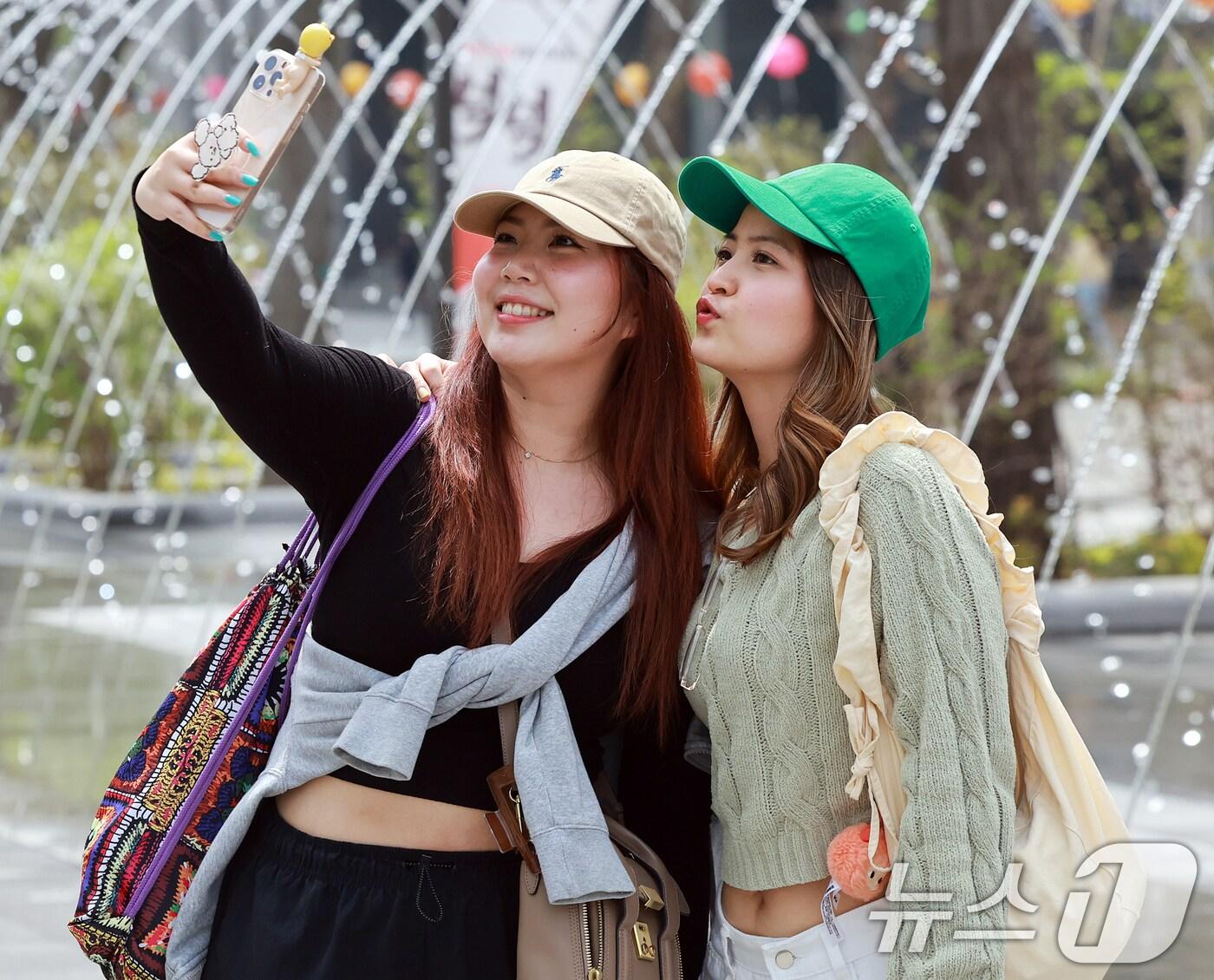 본문 이미지 - 서울 종로구 광화문광장을 찾은 외국인 관광객들이 분수 터널을 배경으로 추억을 남기고 있다.2025.4.18/뉴스1 ⓒ News1 김진환 기자