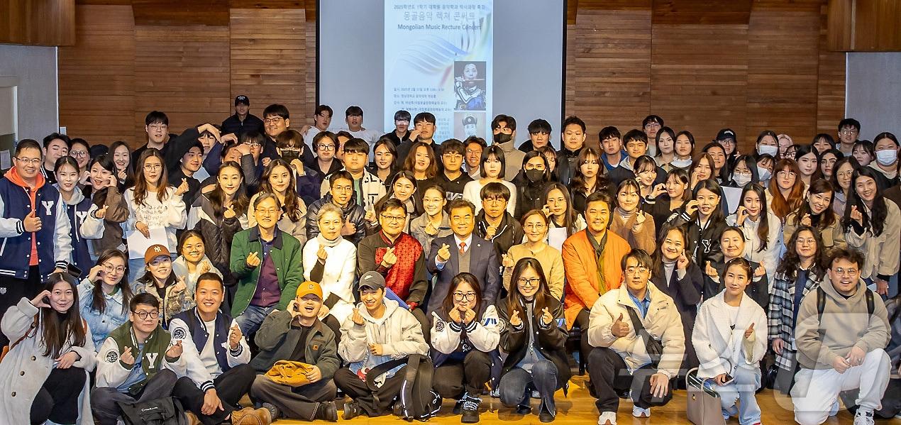본문 이미지 - 영남대와 몽골국립문화예술대의 교류 협력을 기념해 열린 콘서트에서 두 대학 학생과 관계자들이 기념촬영하는 모습. (영남대 제공)