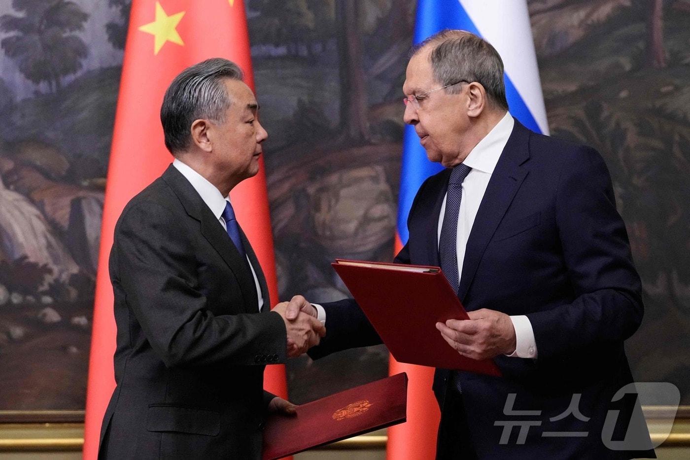 본문 이미지 - 세르게이 라브로프 러시아 외무장관과 왕이 중국 외교부장이 1일(현지시간) 모스크바에서 회담을 마친 뒤 조인식에 참석해 악수를 하고 있다. 2025.04.02 ⓒ AFP=뉴스1