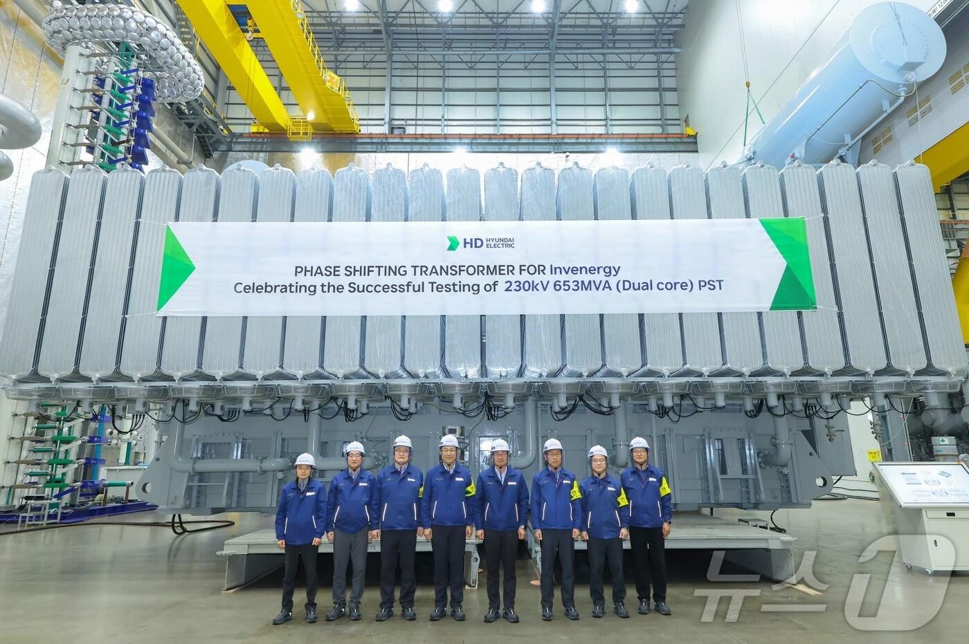 HD현대일렉트릭 변압기 공장에서 230킬로볼트(kV)급 653MVA 위상조정변압기의 최종 승인시험 이후 임직원들이 기념사진을 촬영하는 모습(HD현대 제공)