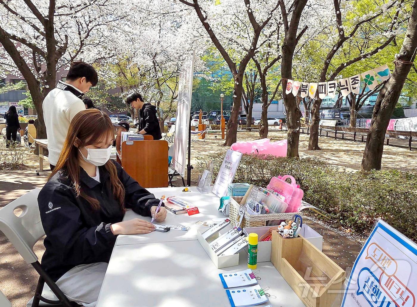본문 이미지 - 영진전문대 학생들이 도서관 앞 벚꽃 숲길에서 북피크닉을 즐기고 있다. (영진전문대 제공)