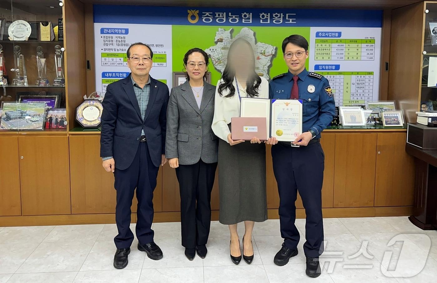 충북 괴산경찰서 관계자가 2일 전화금융사기&#40;보이스피싱&#41; 피해 예방에 이바지한 증평농협 직원에게 경찰서장 감사장을 수여하고 있다.&#40;괴산경찰서 제공&#41;/뉴스1